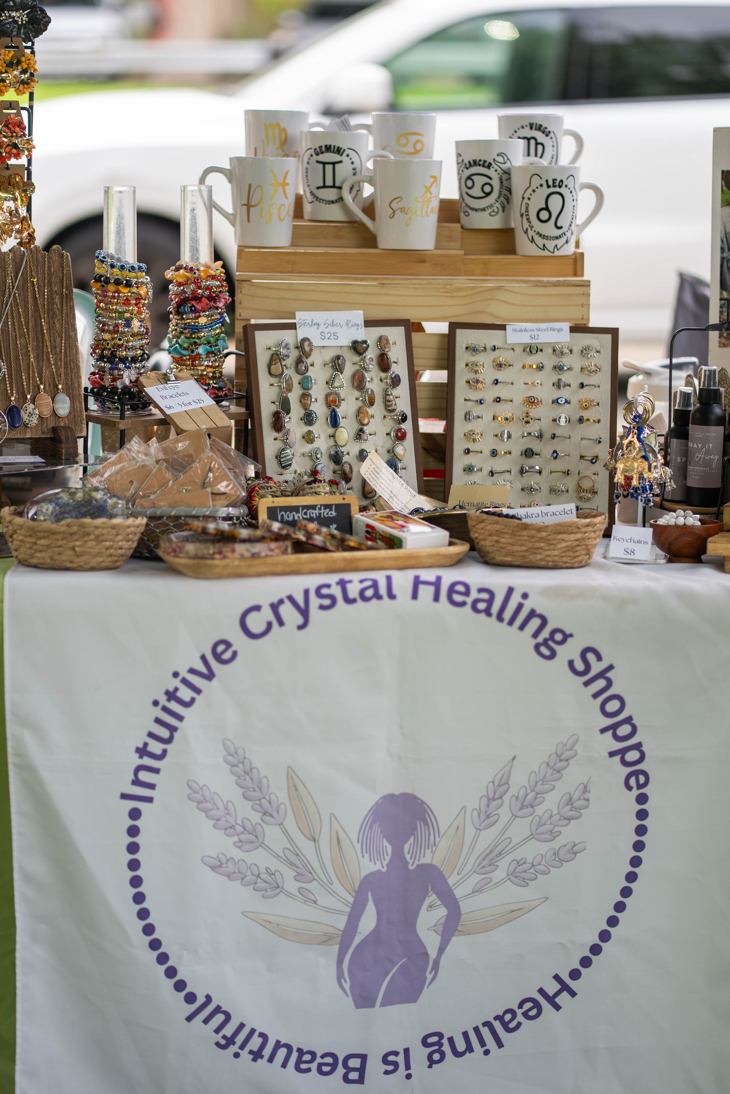 Jewelry, mugs, and handmade goods on a vendor table