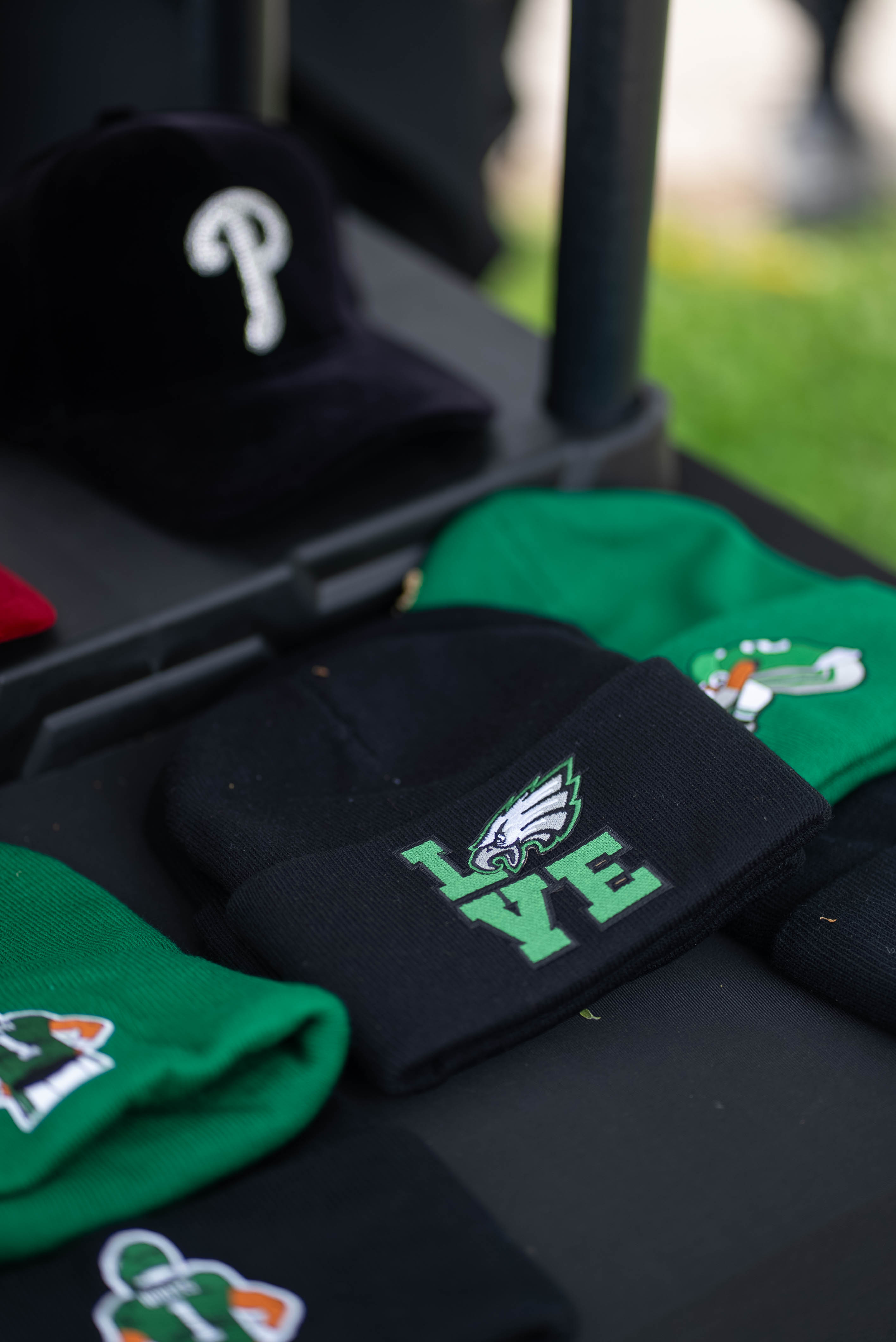 Green and black hats displayed at a vendor table